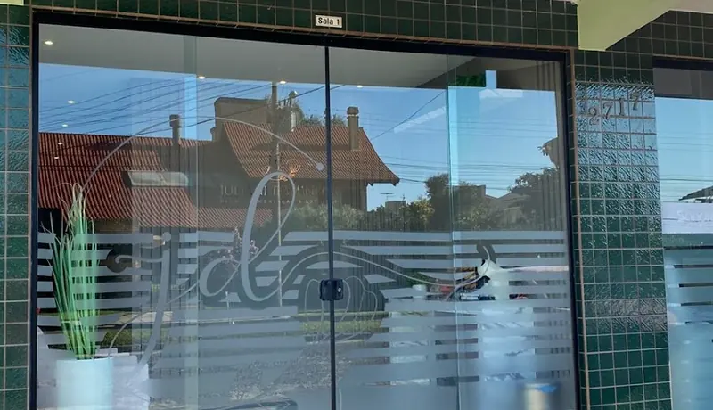 Porta de vidro do consultório, com o número 2717 e a placa da sala 1